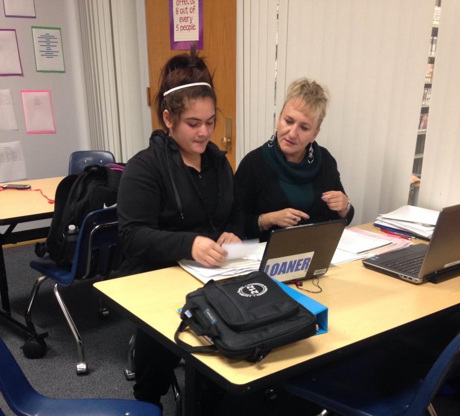 Math coach Ms. Marta Grochola sits down with a student for a tutoring session.