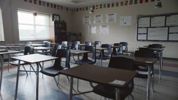 Forward tracking shot an empty classroom filled with unfilled student desks.